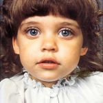 Color portrait of girl with big beautiful eyes in white dress looking at camera